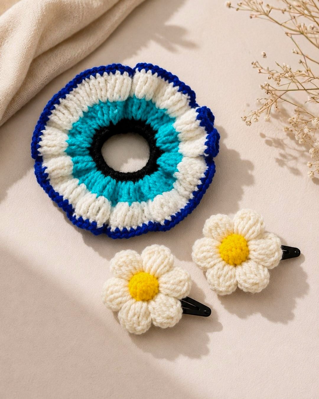 A crochet nazar scrunchie with daisy clips