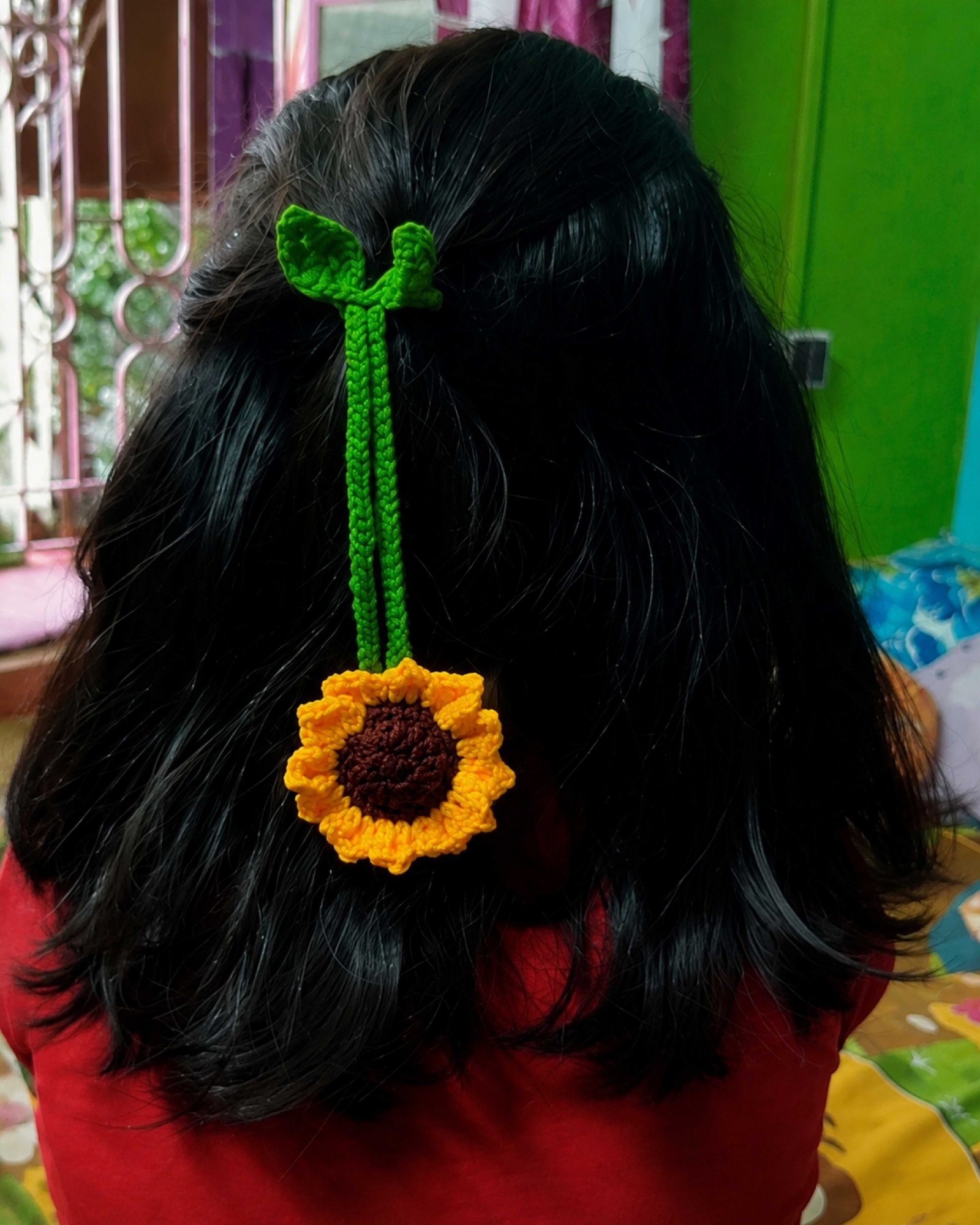 A sunflower charm tied into hair